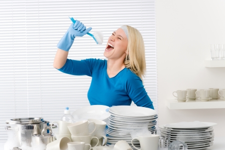 <BODY>Die Reinigung führt man am besten mit einer sauberen Spulbürste durch, die gut in Fugen und Ecken gelangt.</BODY> Frau hat Spaß beim Putzen in der Küche