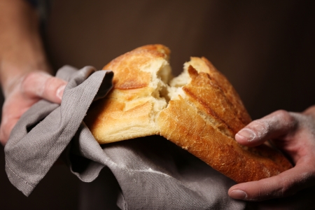 <BODY>Im Gärkorb bekommt der Teig seine Oberfläche, Form und Textur und reift zum fertigen Brot heran.</BODY> Mann bricht selbstgemachtes Brot in zwei Hälften