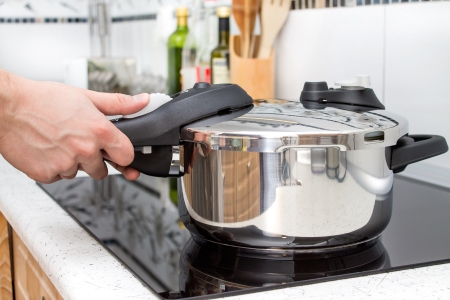 Schnellkochtopf Person beim Kochen mit einem Schnellkochtopf