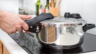 Person beim Kochen mit einem Schnellkochtopf
