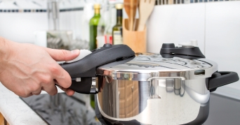 Person beim Kochen mit einem Schnellkochtopf