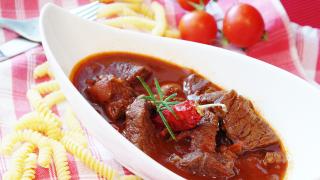 Gulasch in Teller mit Gulaschkanone zubereitet