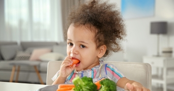 Avent Dampfgarer Kind isst lecker Karotten und Brockoli aus einem Avent Dampfgarer