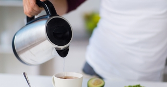 Person bei Benutzung eines Wasserkochers