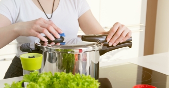 Frau hantiert mit Fissler Schnellkochtopf