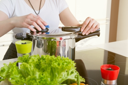 Fissler Schnellkochtopf Frau hantiert mit Fissler Schnellkochtopf