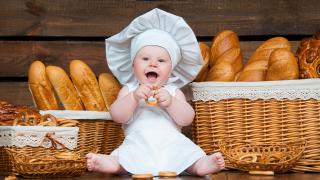 Liebes Baby freut sich über frisches Brot aus dem Gärkörbchen