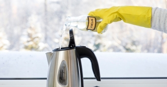 Person beim Wasserkocher entkalken